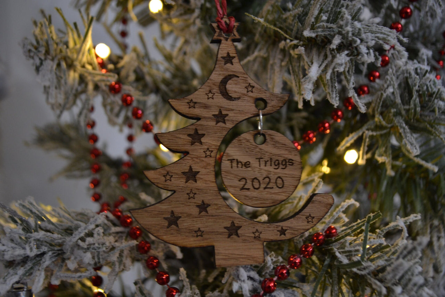 "Personalised Christmas tree bauble with custom name engraved, made from natural wood or clear acrylic."