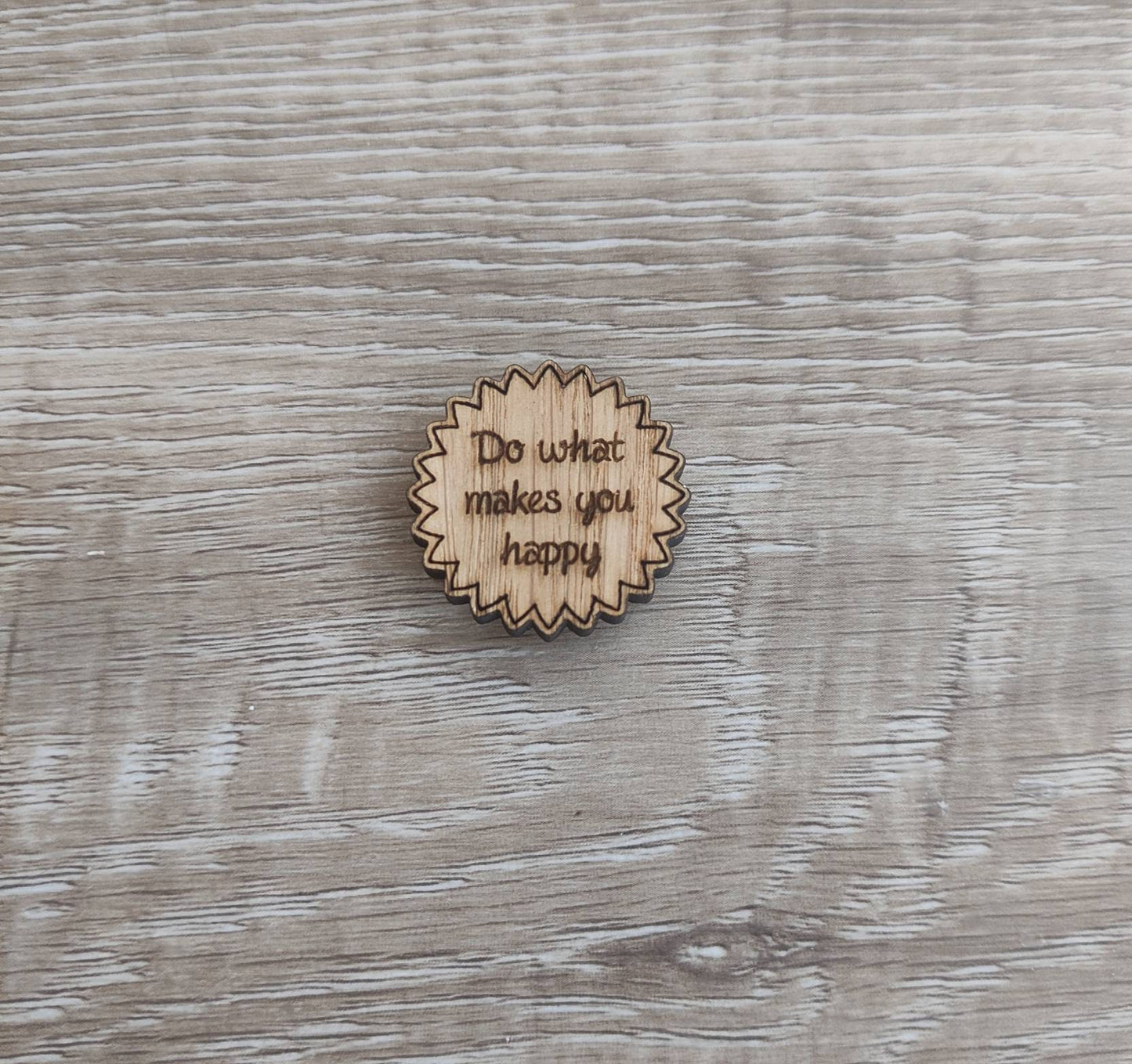 Round soft jagged edges needle minder with "Do What Makes You Happy" engraved: