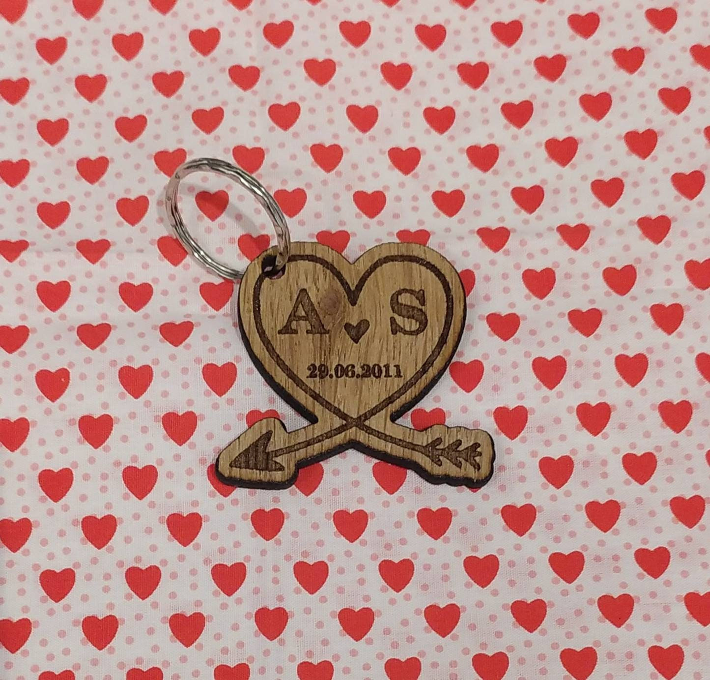 Heart-shaped wooden keyring with an engraved arrow, featuring initials and a memorable date, perfect for anniversaries and special occasions.