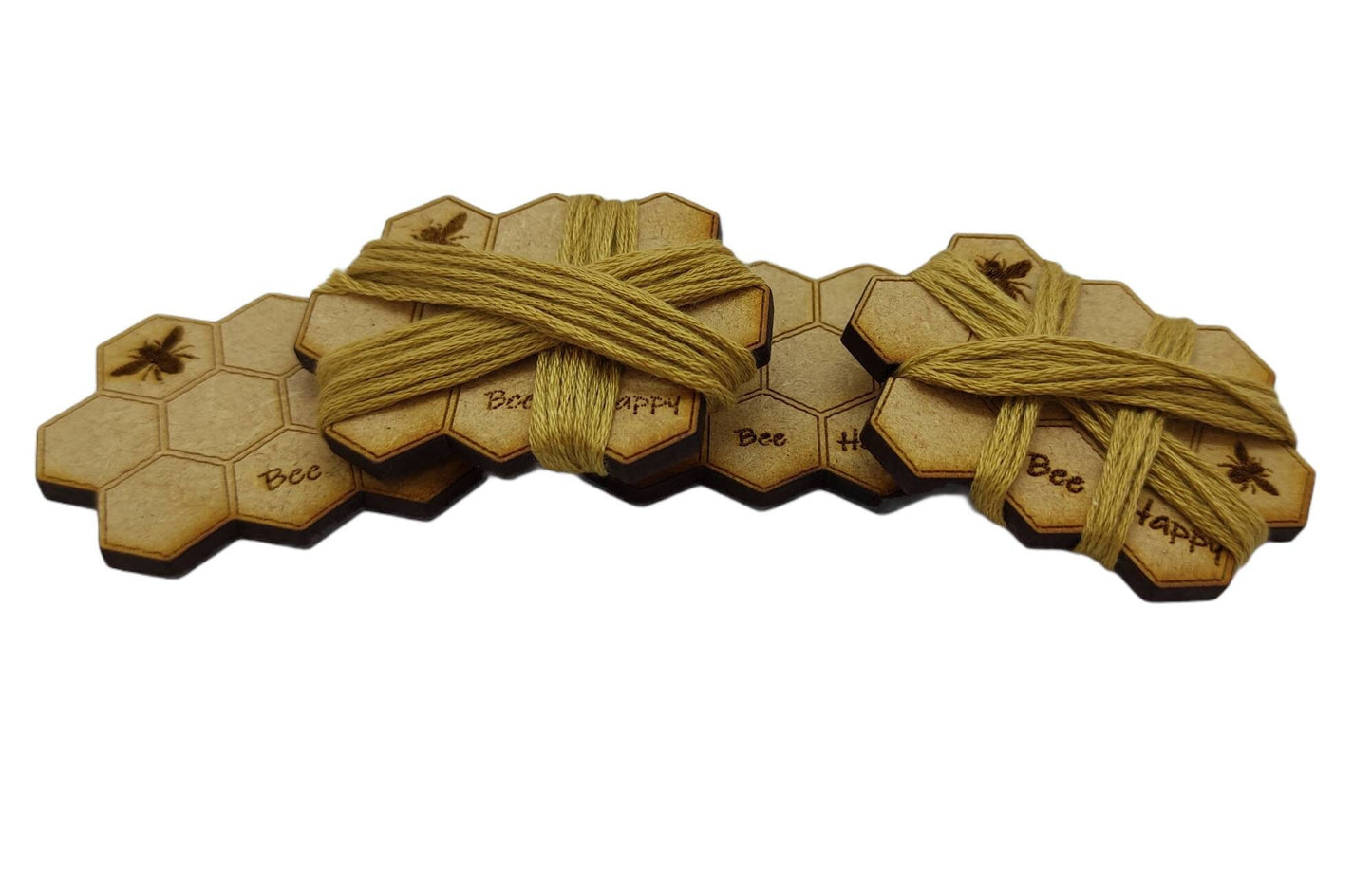 Honeycomb-shaped bobbin for keeping your thread tidy, engraved with bees and 'Bee Happy' design.