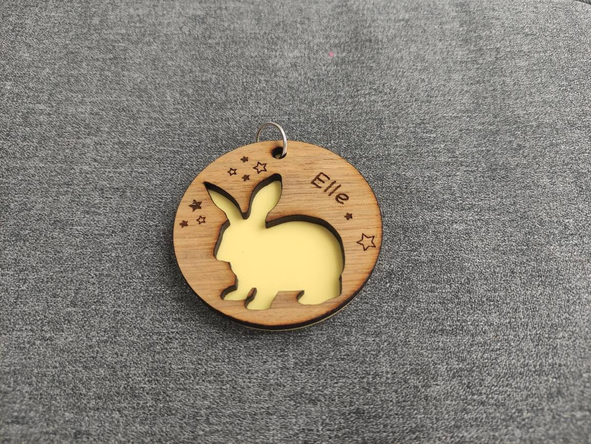 Circular keyring with a cut-out bunny rabbit design backed with colourful acrylic, laser engraved with a personalised name on oak veneer.