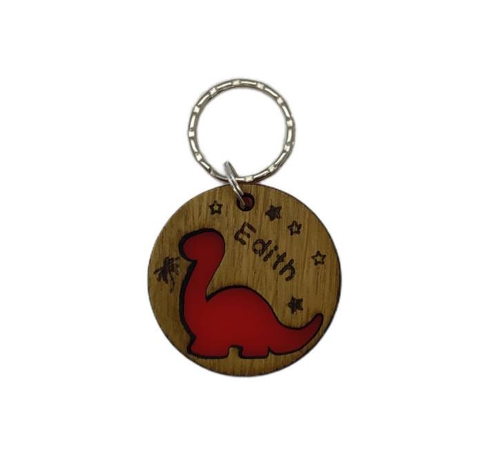 Round keyring with a Diplodocus shape cut out and backed with coloured acrylic, engraved with any name.