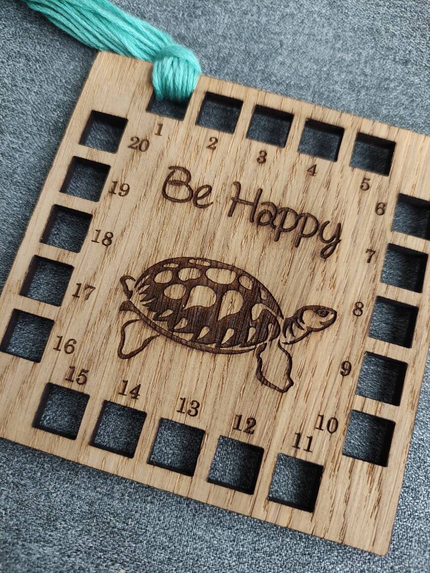 Square shape thread holder, with tortoise and "be happy" engraved in the middle. 20 holes for thread.