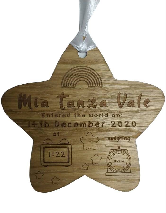 Personalised oak veneer wooden star engraved with a newborn's full name, date of birth, time, and weight. Finished with a white string for hanging, making it a thoughtful keepsake for families.