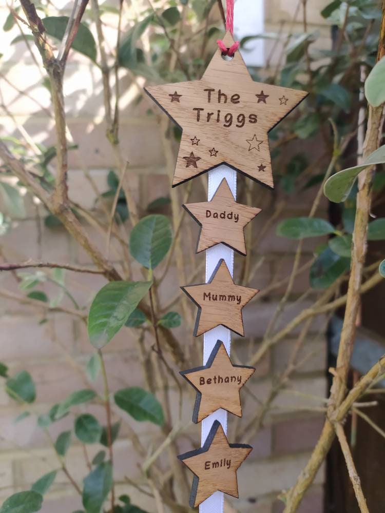 "Personalised Family Christmas Star Tree Hanger with laser-cut stars, custom engraved with family names, featuring red, white, or green hanging string."