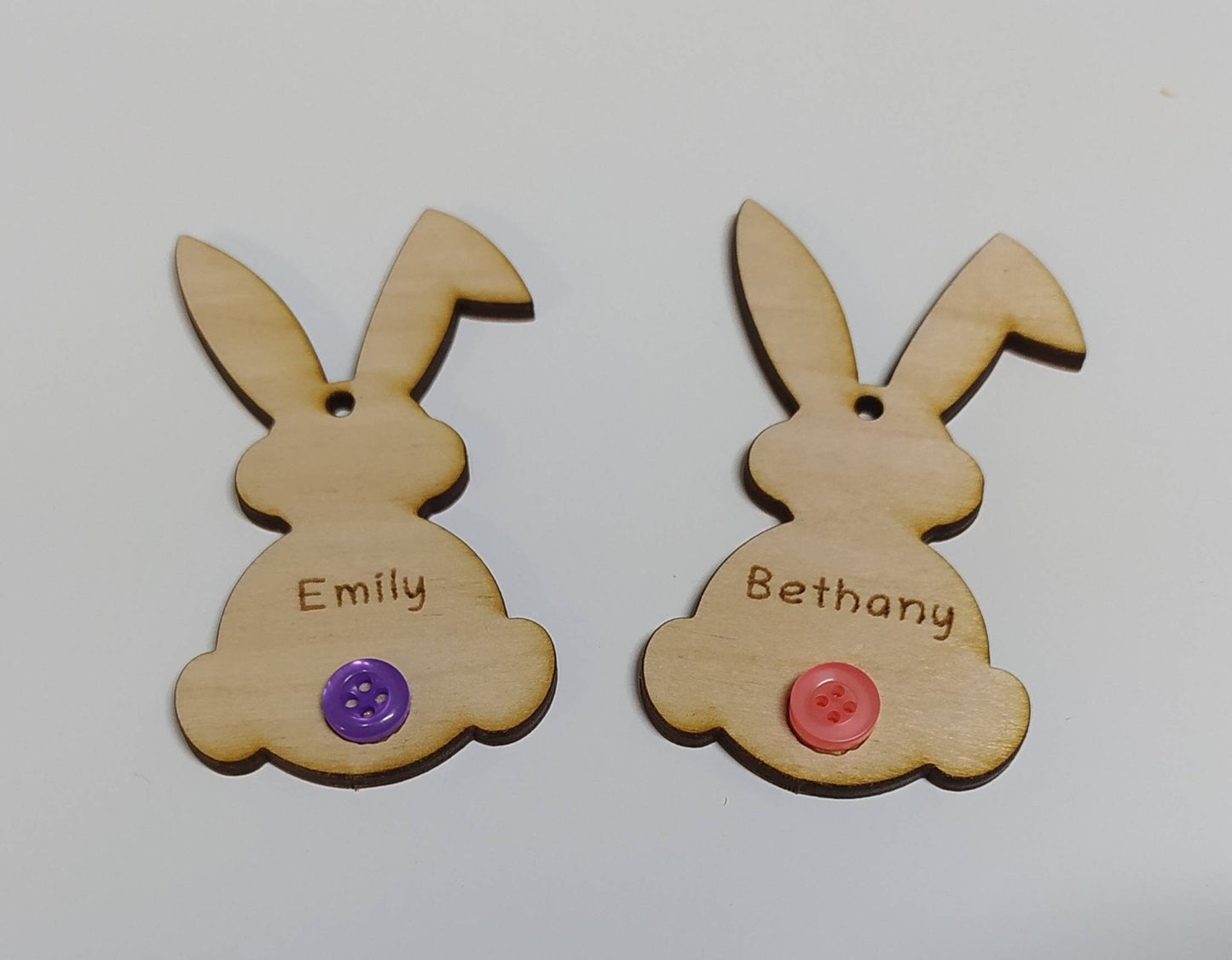 Easter bunny-shaped hanging decoration, engraved with a personalised name and featuring a coloured button as the tail.