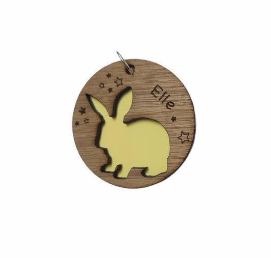 Circular keyring with a cut-out bunny rabbit design backed with colourful acrylic, laser engraved with a personalised name on oak veneer.