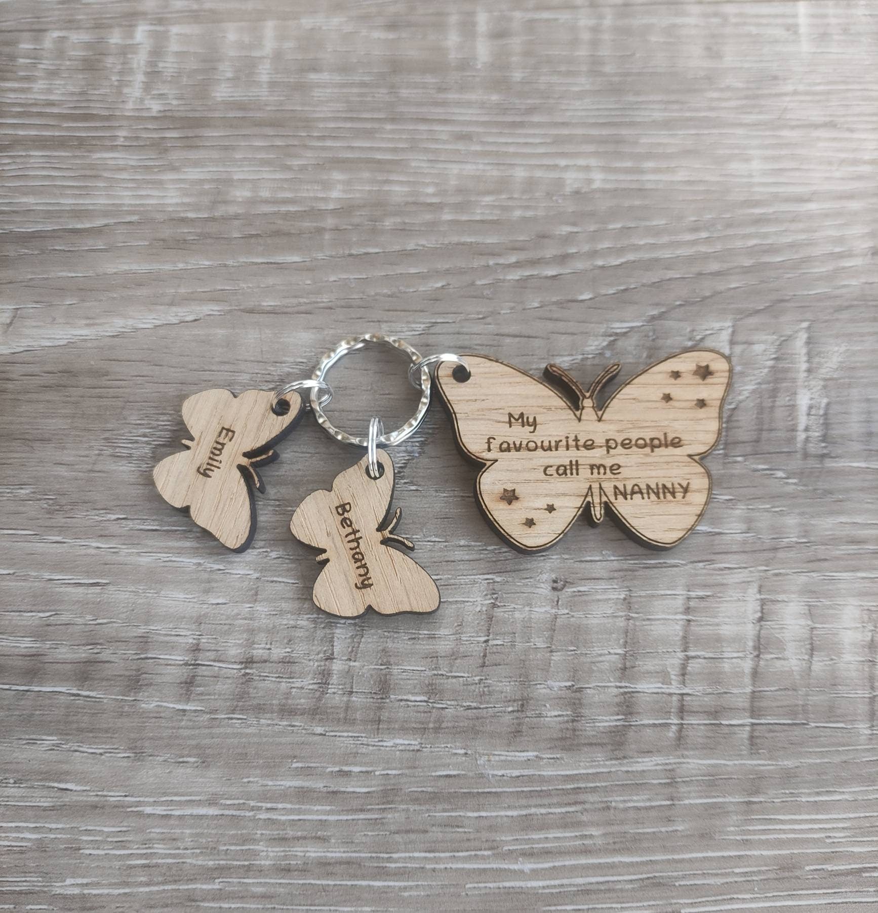 Butterfly design keyring engraved with "My favourite people call me NANNY" and custom butterfly-shaped charms.