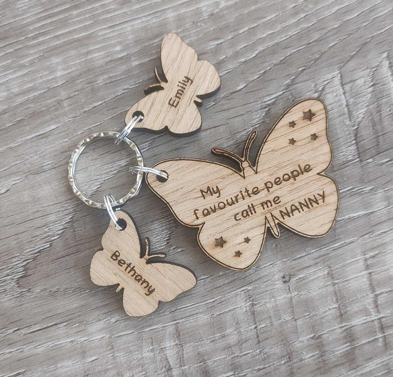Butterfly design keyring engraved with "My favourite people call me NANNY" and custom butterfly-shaped charms.
