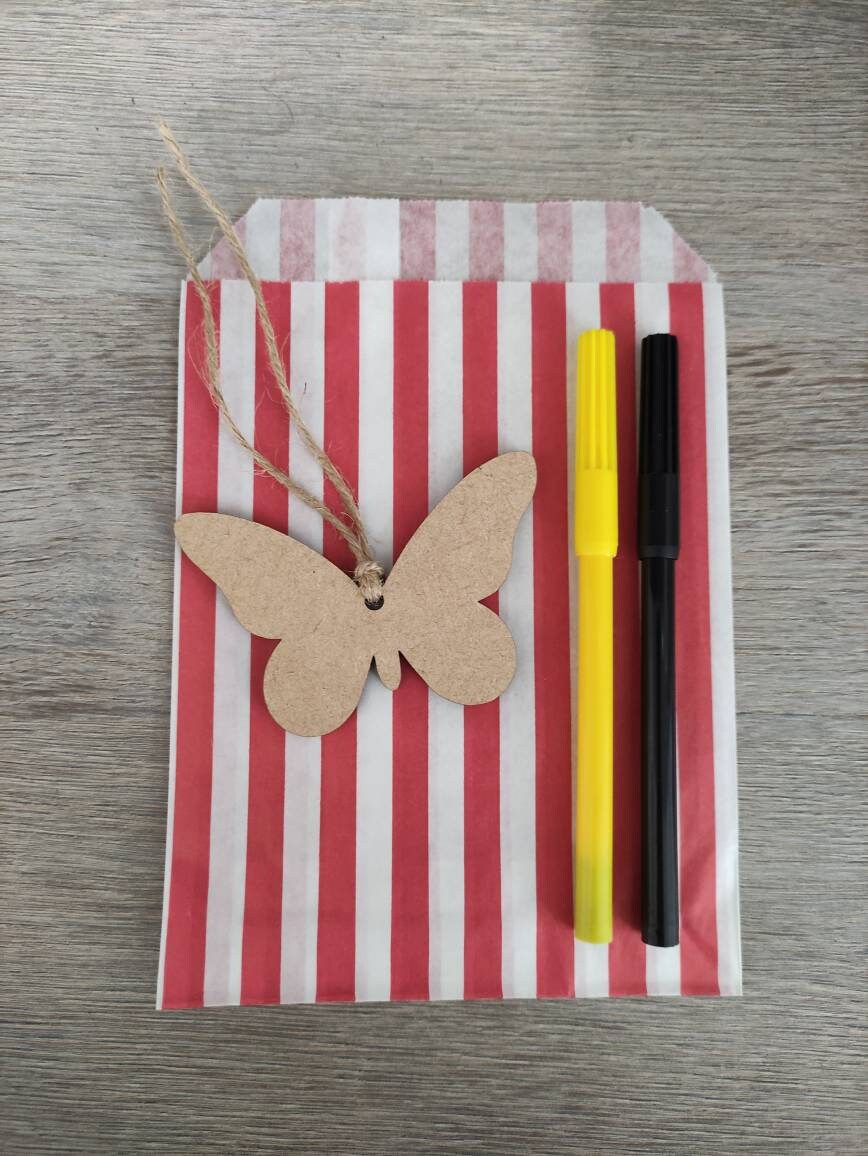 Wooden laser-cut shape with a hole at the top for hanging, string included, and 2 coloured pens inside a paper bag.