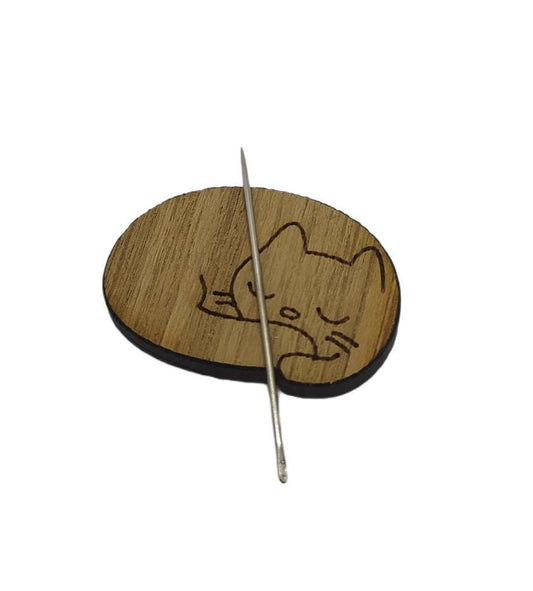 Cat-shaped needle minder with a strong magnet to hold needles, perfect for embroidery and cross-stitch projects.