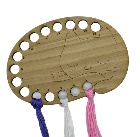 Cat thread holder in a sleeping cat design with 16 holes for thread.