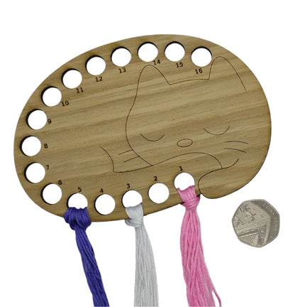 Cat thread holder in a sleeping cat design with 16 holes for thread.