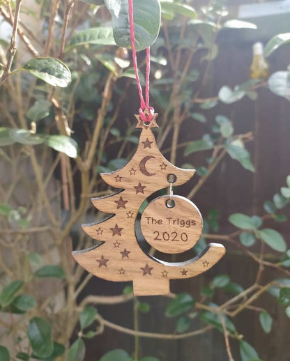 "Personalised Christmas tree bauble with custom name engraved, made from natural wood or clear acrylic."