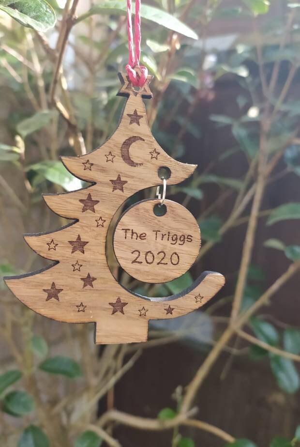 "Personalised Christmas tree bauble with custom name engraved, made from natural wood or clear acrylic."