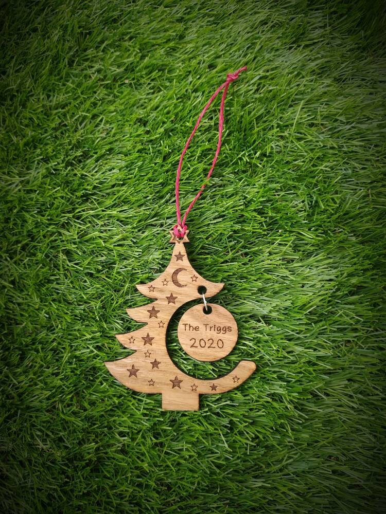 "Personalised Christmas tree bauble with custom name engraved, made from natural wood or clear acrylic."