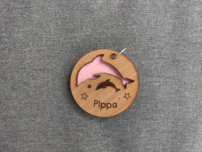 Circle keyring with a cut-out dolphin shape, backed with coloured acrylic, engraved with any name.