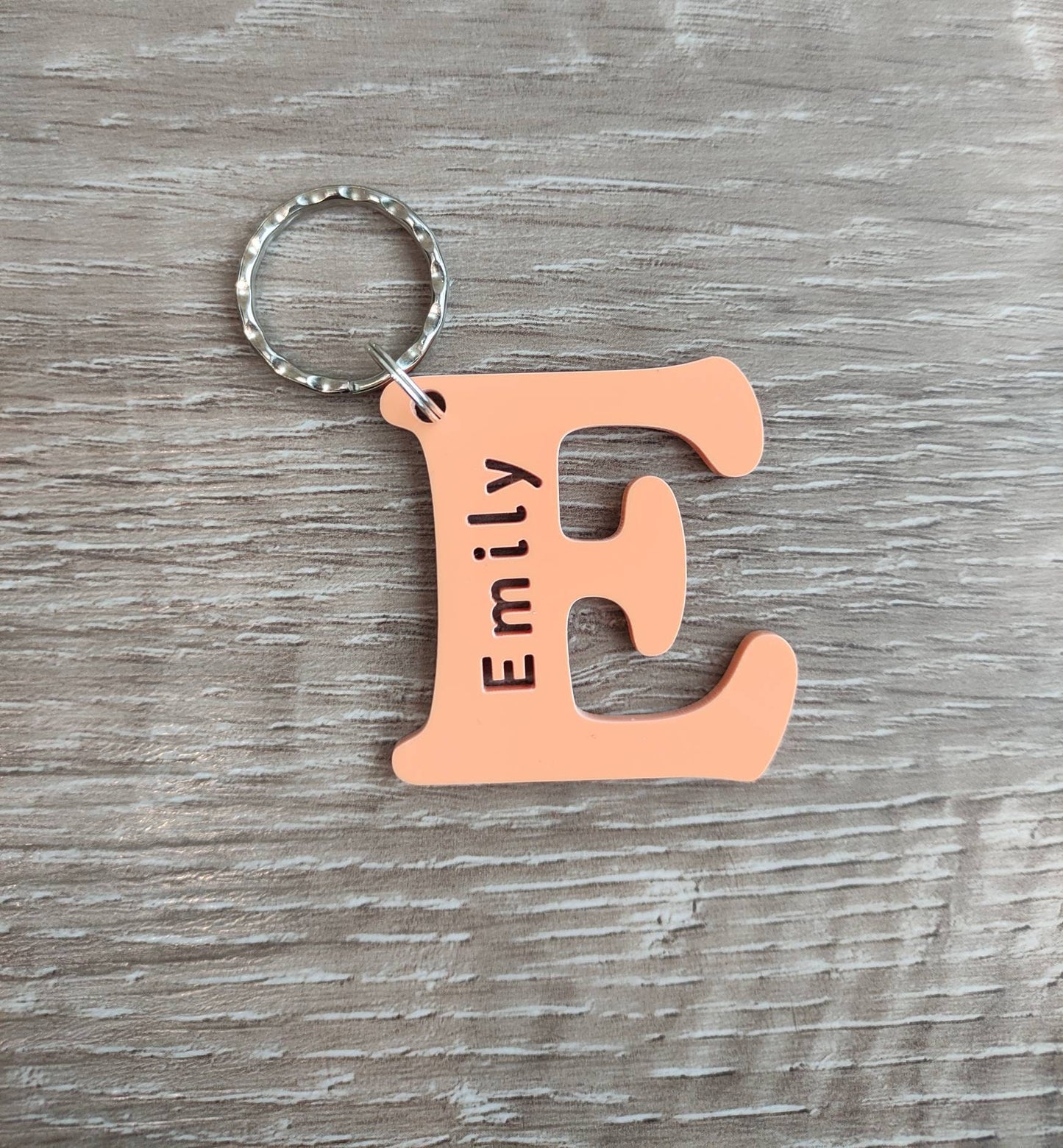 Personalised coloured acrylic keyring with engraved first letter, ideal for key identification and unique gifts.