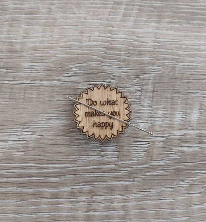 Round soft jagged edges needle minder with "Do What Makes You Happy" engraved: