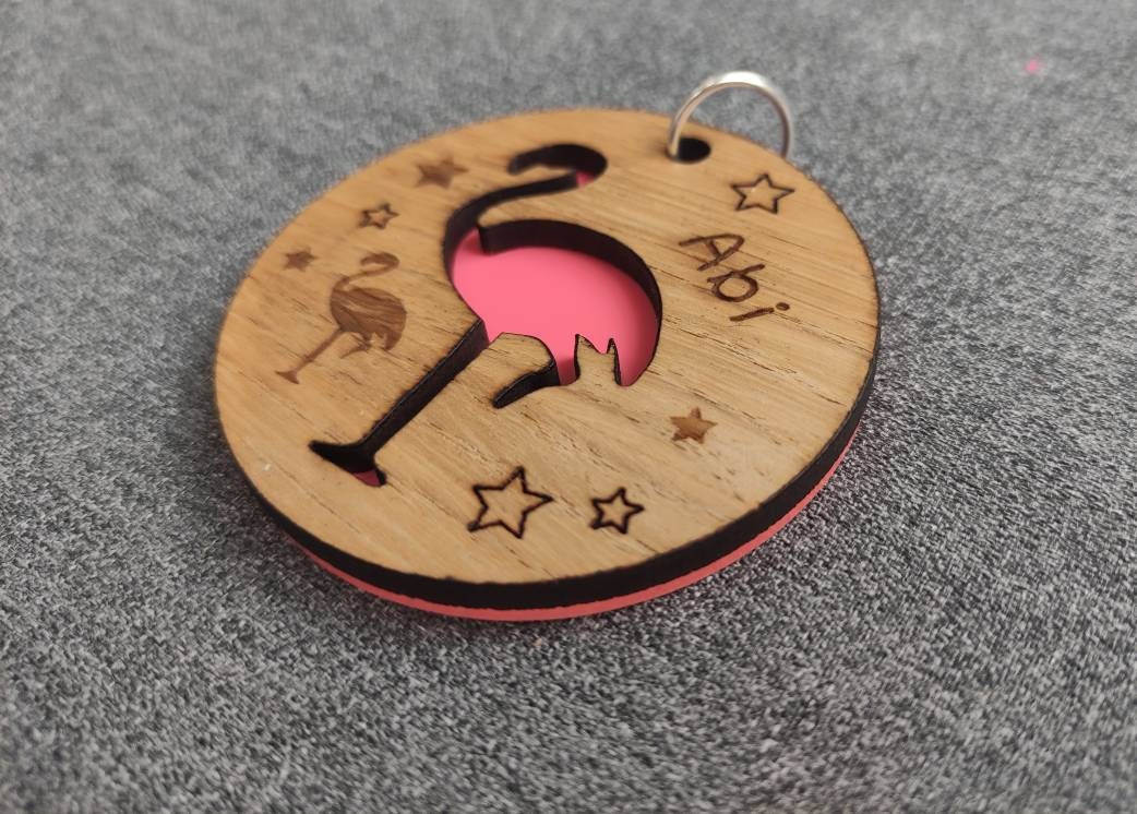 Round wooden keyring with colourful acrylic backing and a laser-cut Flamingo design – personalised with engraved child’s name, perfect for school bags.