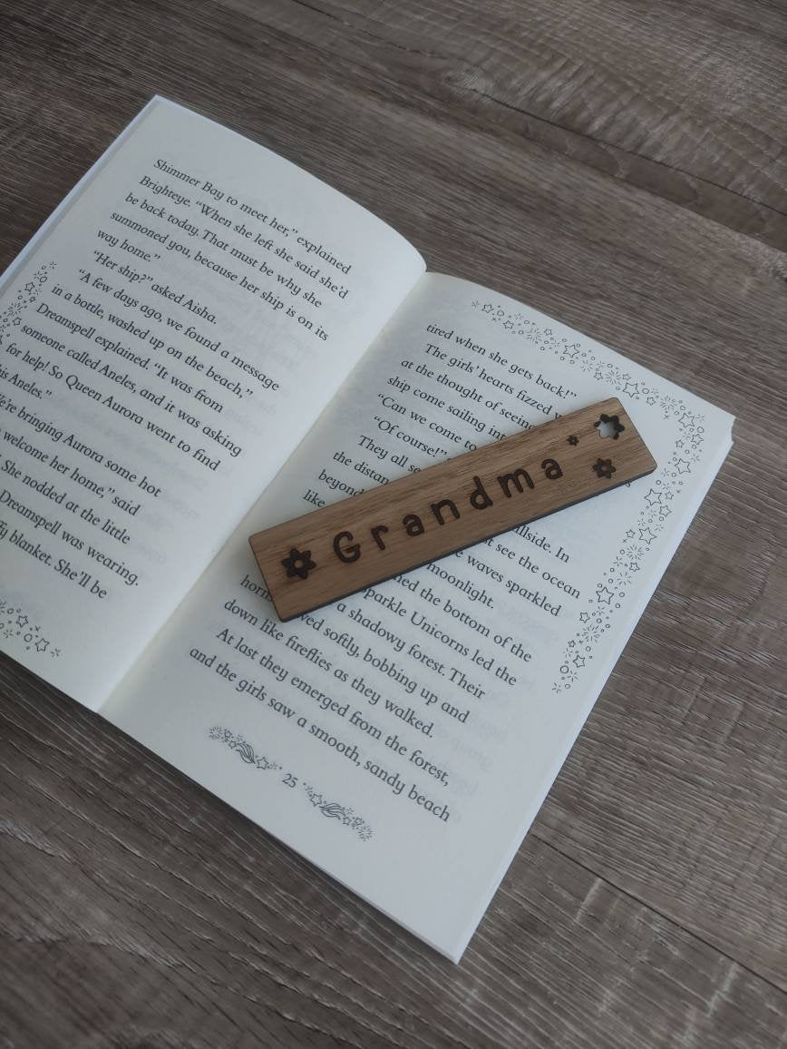 Personalised wooden bookmark engraved with flower designs, featuring two coloured ribbons tied at the top. A thoughtful and custom gift for book lovers, made from high-quality wood.