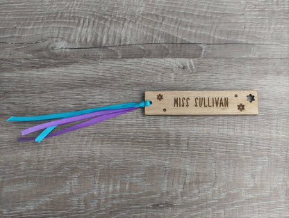 Personalised wooden bookmark engraved with flower designs, featuring two coloured ribbons tied at the top. A thoughtful and custom gift for book lovers, made from high-quality wood.