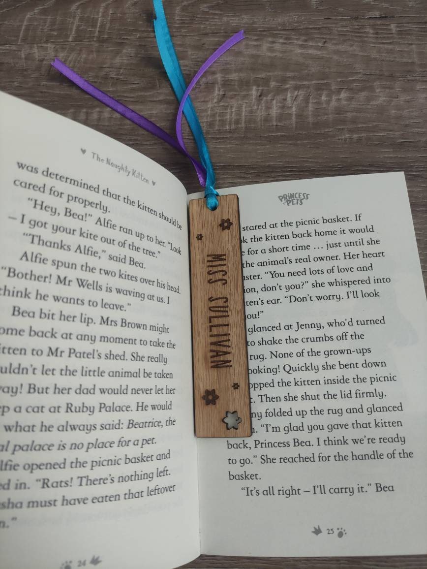 Personalised wooden bookmark engraved with flower designs, featuring two coloured ribbons tied at the top. A thoughtful and custom gift for book lovers, made from high-quality wood.