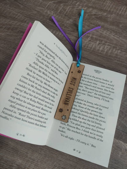 Personalised wooden bookmark engraved with flower designs, featuring two coloured ribbons tied at the top. A thoughtful and custom gift for book lovers, made from high-quality wood.