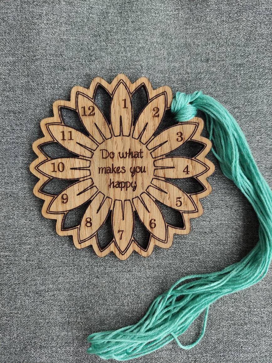 Flower thread holder with "Do What Makes You Happy" engraved, featuring holes for 12 threads.