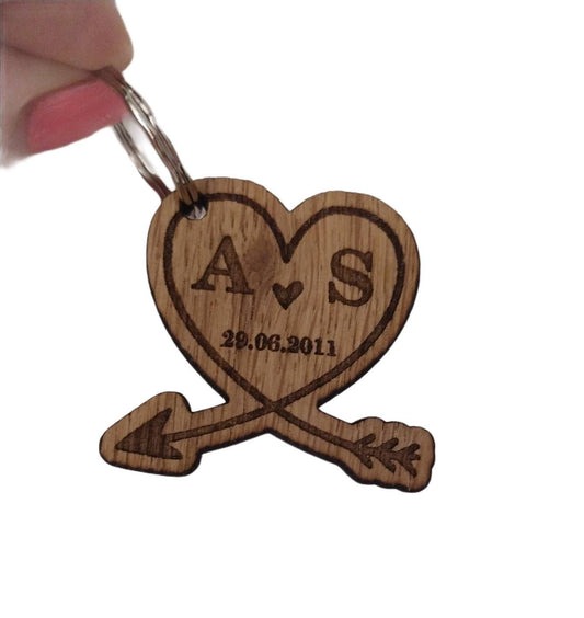 Heart-shaped wooden keyring with an engraved arrow, featuring initials and a memorable date, perfect for anniversaries and special occasions.