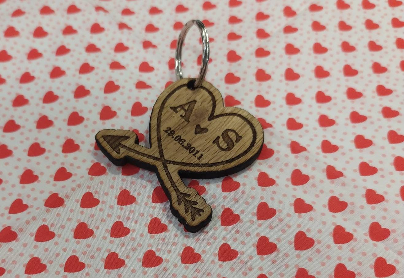Heart-shaped wooden keyring with an engraved arrow, featuring initials and a memorable date, perfect for anniversaries and special occasions.