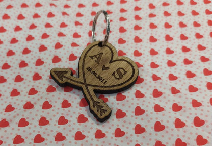 Heart-shaped wooden keyring with an engraved arrow, featuring initials and a memorable date, perfect for anniversaries and special occasions.
