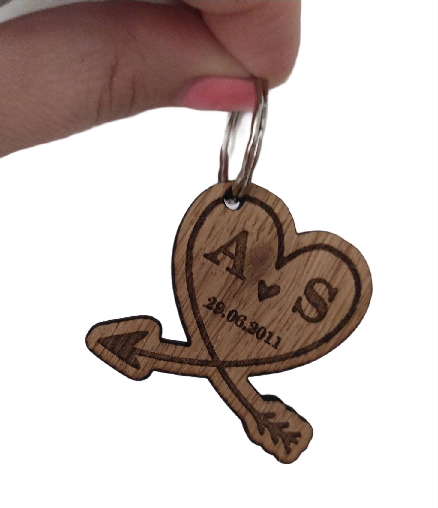 Heart-shaped wooden keyring with an engraved arrow, featuring initials and a memorable date, perfect for anniversaries and special occasions.