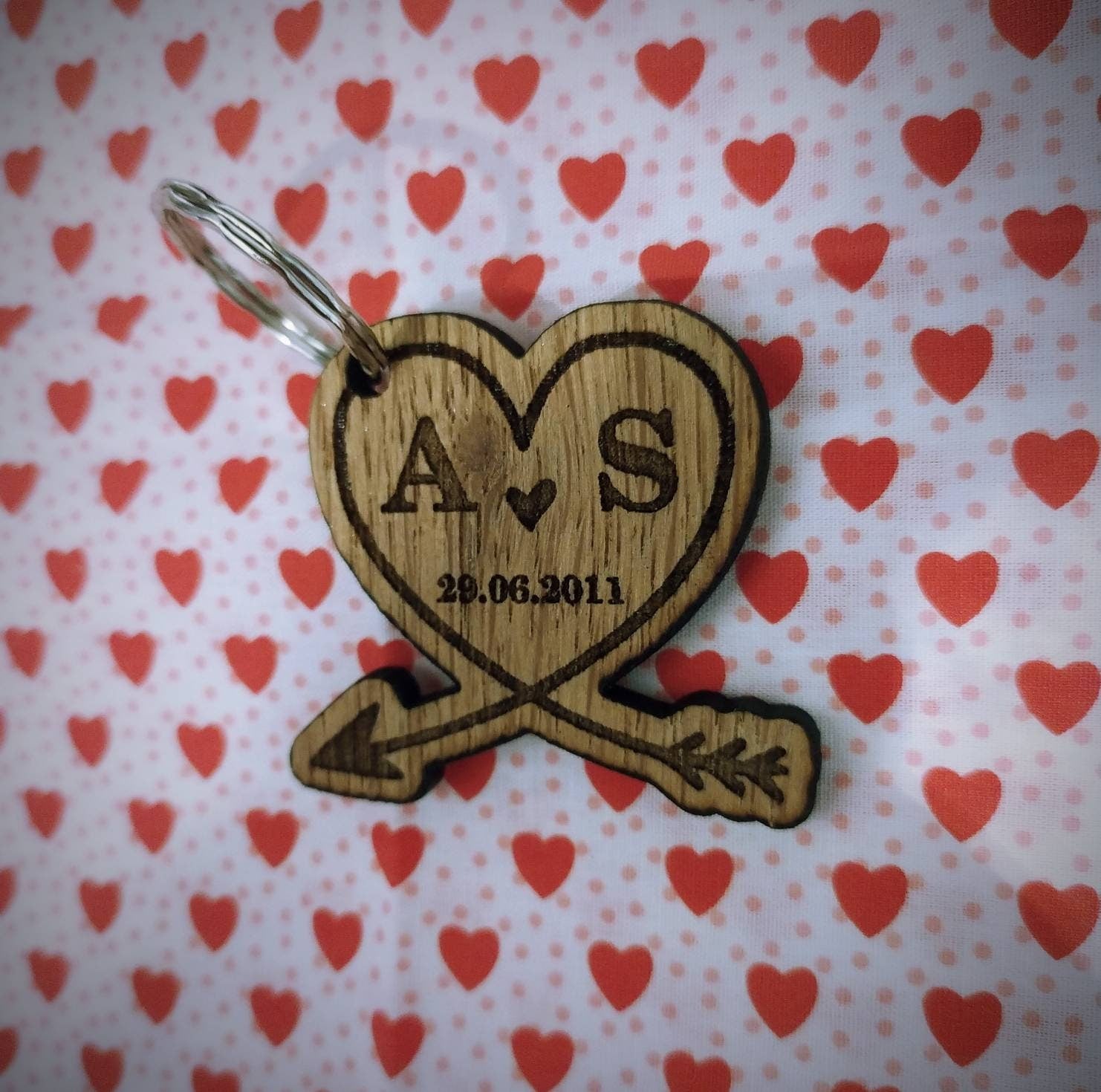 Heart-shaped wooden keyring with an engraved arrow, featuring initials and a memorable date, perfect for anniversaries and special occasions.