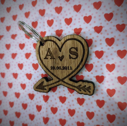 Heart-shaped wooden keyring with an engraved arrow, featuring initials and a memorable date, perfect for anniversaries and special occasions.