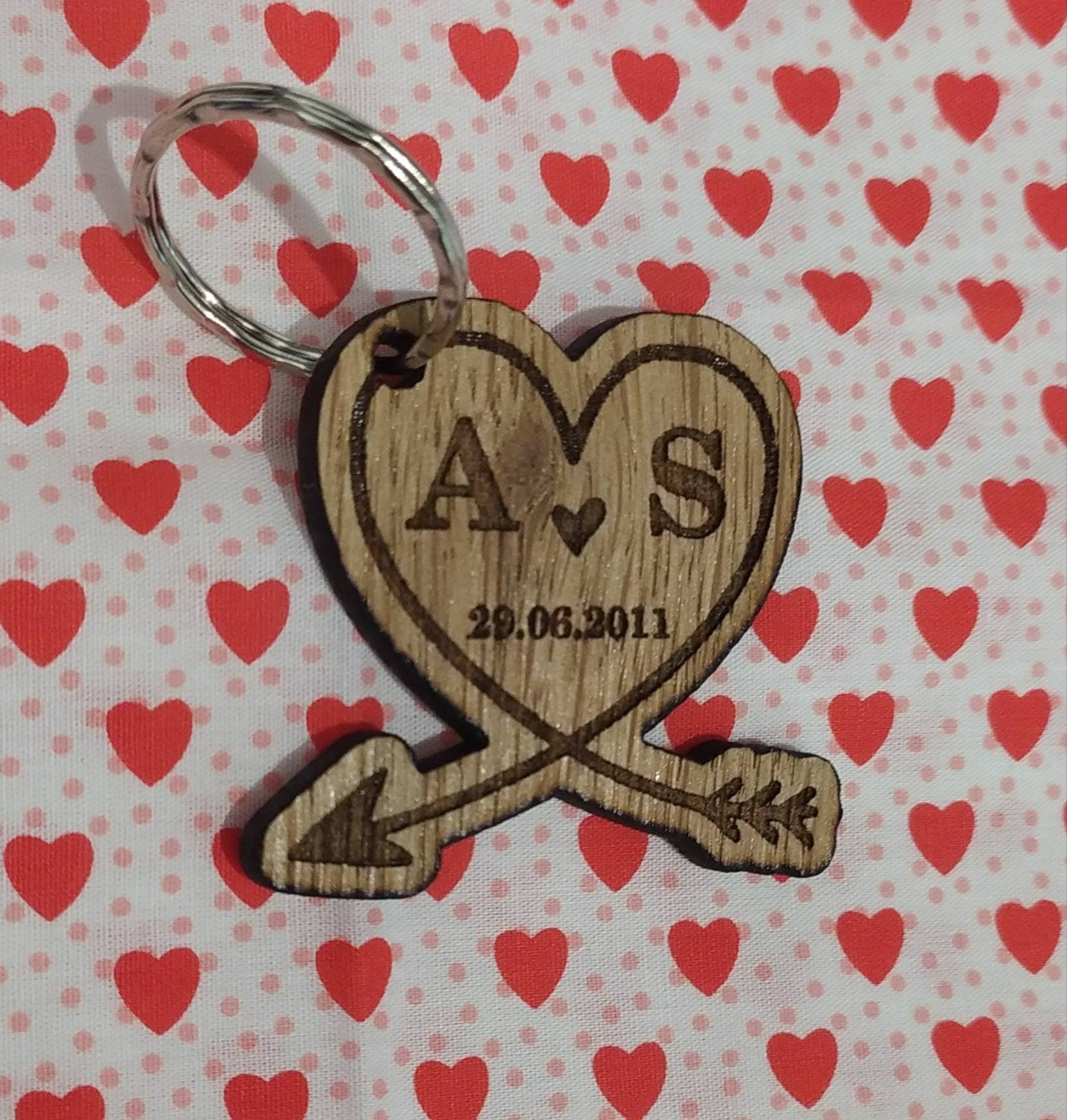 Heart-shaped wooden keyring with an engraved arrow, featuring initials and a memorable date, perfect for anniversaries and special occasions.