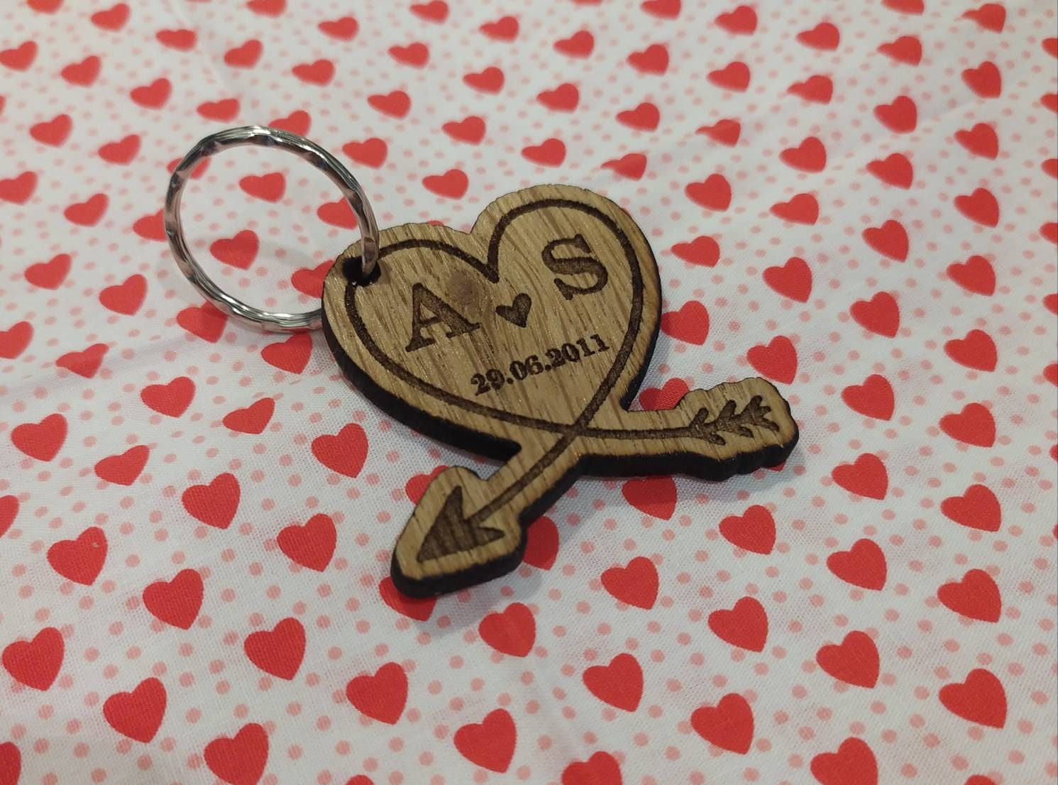 Heart-shaped wooden keyring with an engraved arrow, featuring initials and a memorable date, perfect for anniversaries and special occasions.