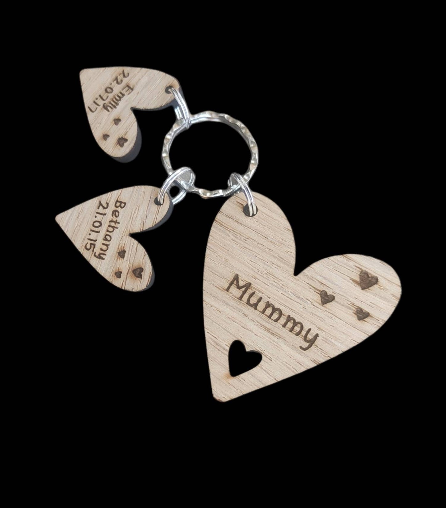 Personalised heart-shaped wooden keyring engraved with "Mummy" and customisable with charms featuring a child’s name and date of birth.