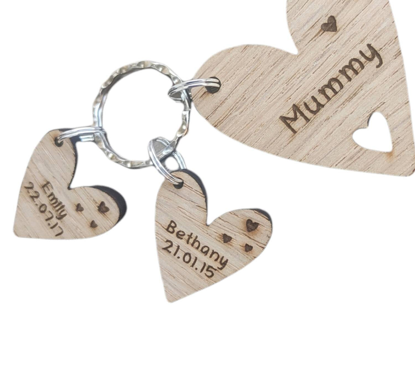 Personalised heart-shaped wooden keyring engraved with "Mummy" and customisable with charms featuring a child’s name and date of birth.