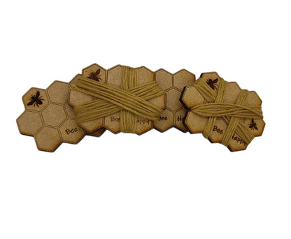 Honeycomb-shaped bobbin for keeping your thread tidy, engraved with bees and 'Bee Happy' design.