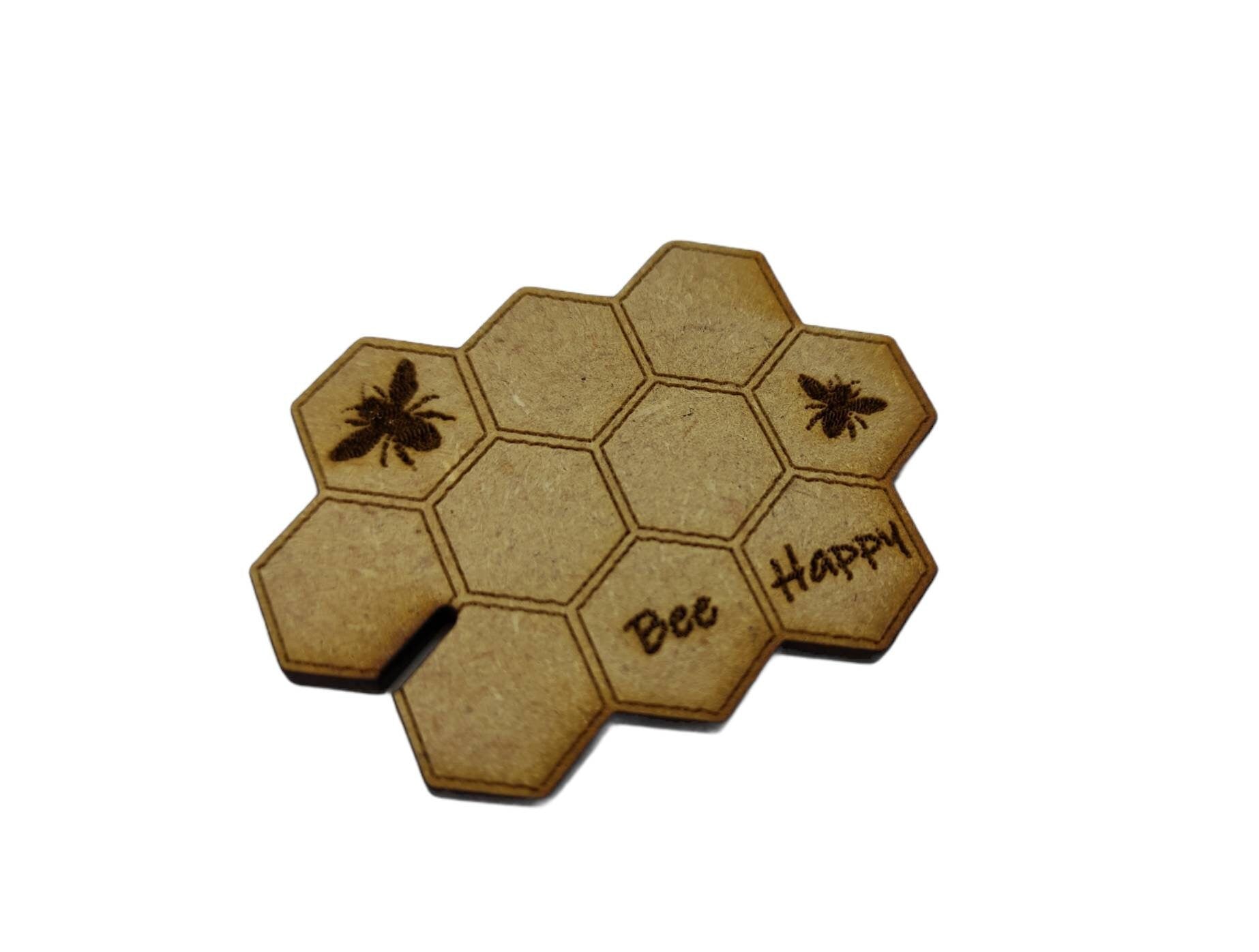 Honeycomb-shaped bobbin for keeping your thread tidy, engraved with bees and 'Bee Happy' design.