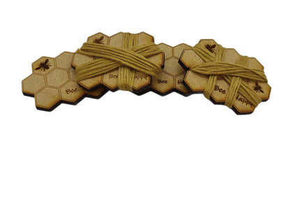 Honeycomb-shaped bobbin for keeping your thread tidy, engraved with bees and 'Bee Happy' design.