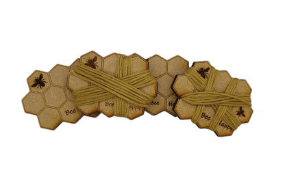 Honeycomb-shaped bobbin for keeping your thread tidy, engraved with bees and 'Bee Happy' design.