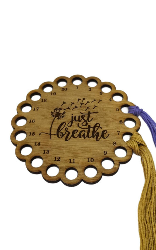 Thread holder in a flower shape with "Just Breathe" engraved, featuring 20 holes for thread.