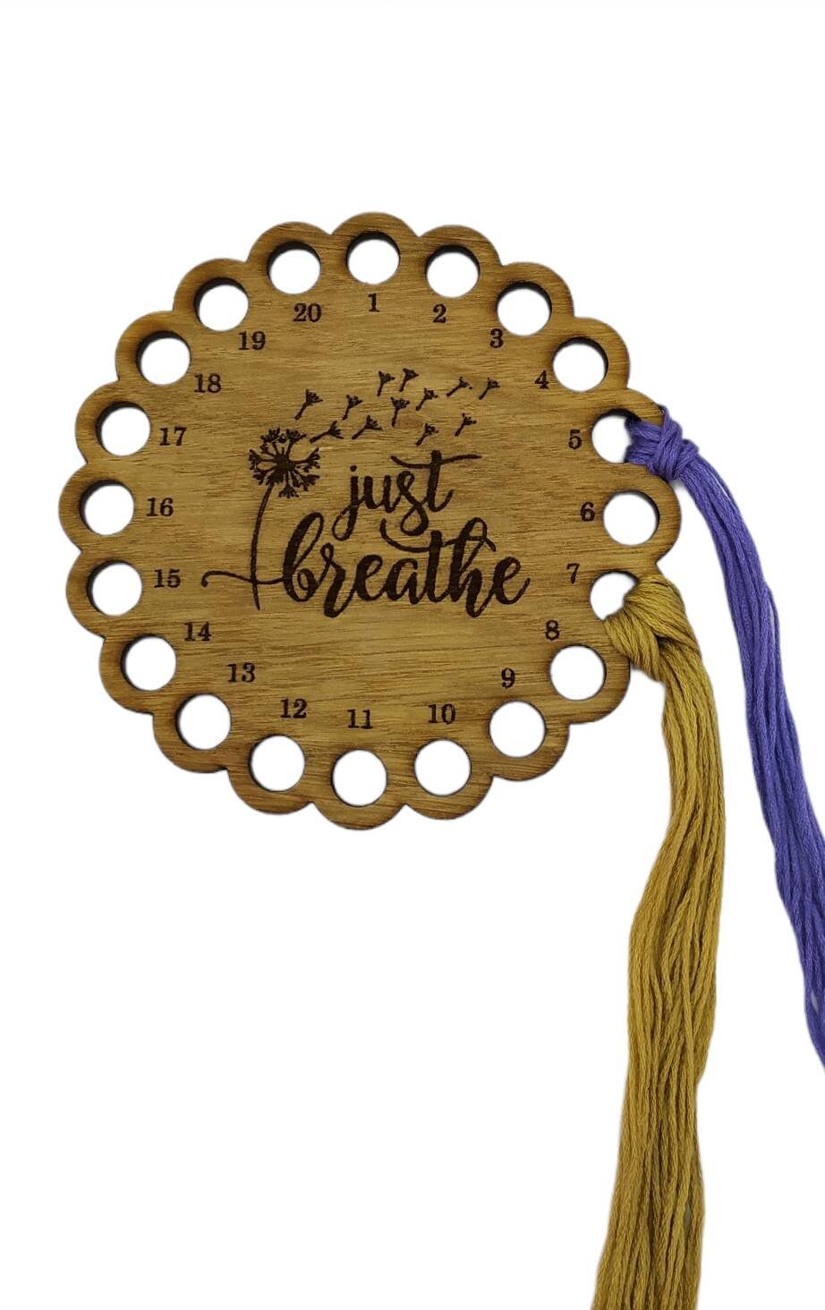 Thread holder in a flower shape with "Just Breathe" engraved, featuring 20 holes for thread.
