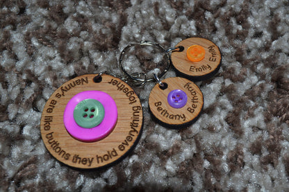 Circle keyring engraved with 'Mum's are like buttons, they hold everything together' around the edge. Two buttons in the middle, with personalised charms featuring children's names and coloured buttons.