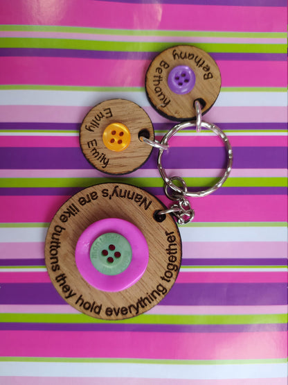 Circle keyring engraved with 'Mum's are like buttons, they hold everything together' around the edge. Two buttons in the middle, with personalised charms featuring children's names and coloured buttons.