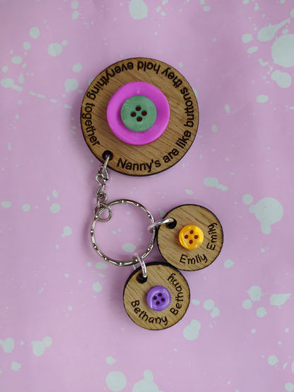 Circle keyring engraved with 'Mum's are like buttons, they hold everything together' around the edge. Two buttons in the middle, with personalised charms featuring children's names and coloured buttons.
