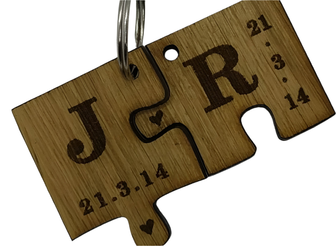2 puzzle piece keyrings engraved with initials and a special date.