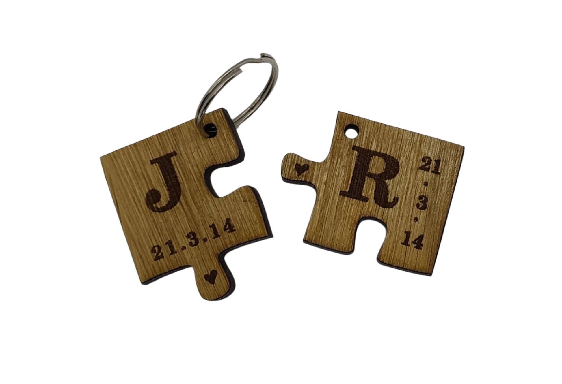 2 puzzle piece keyrings engraved with initials and a special date.